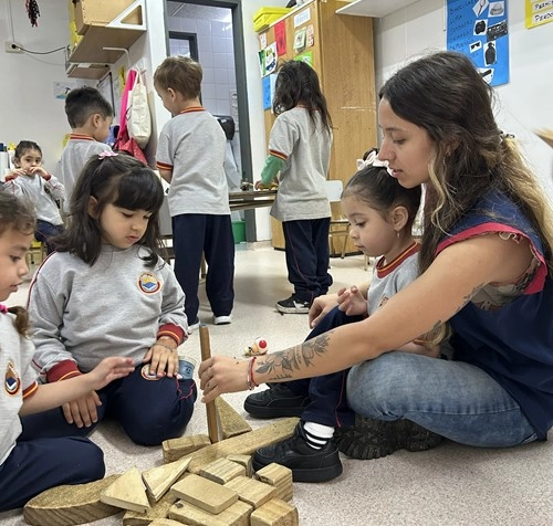 Docente y alumnos del Nivel Inicial del Colegio Alberdi participando en una actividad de aprendizaje y exploración mediante juegos de construcción.