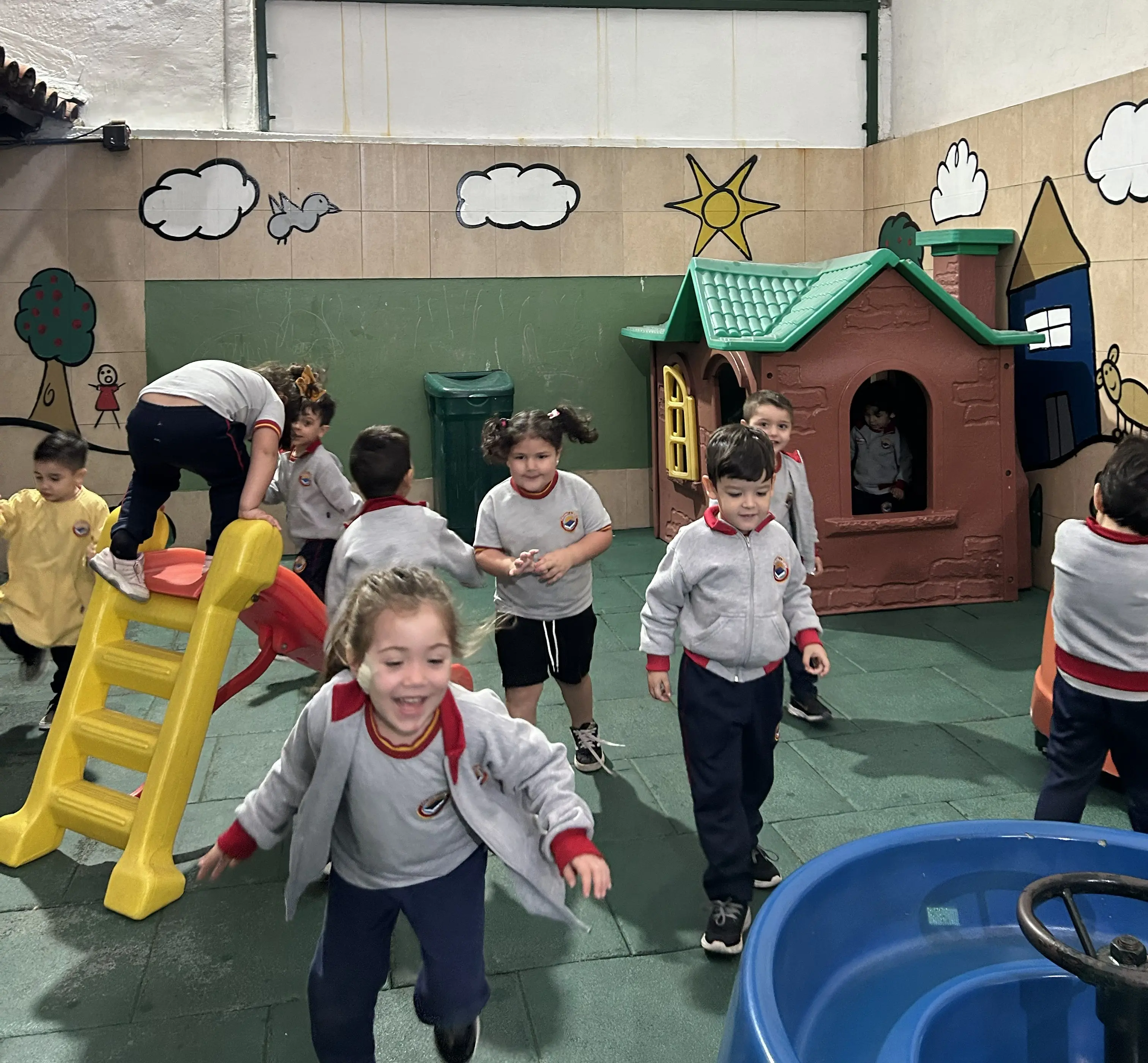 Alumnos del Nivel Inicial del Colegio Alberdi participando en actividades de juego, exploración y desarrollo motriz en el patio escolar.